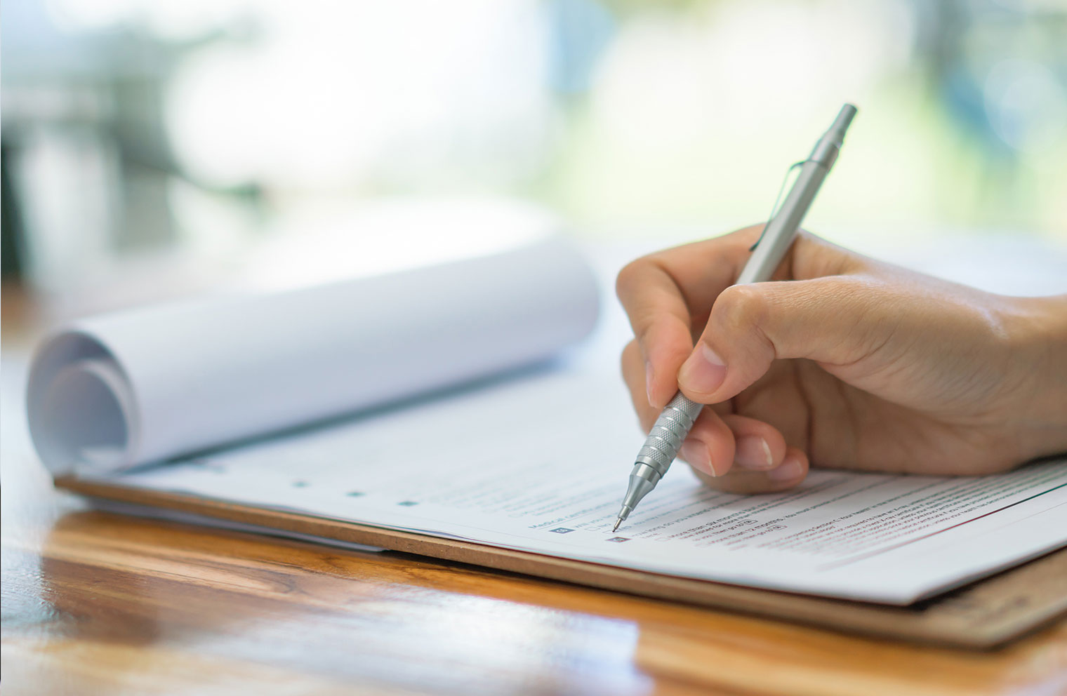 Image of person writing checking off a list on notepad.