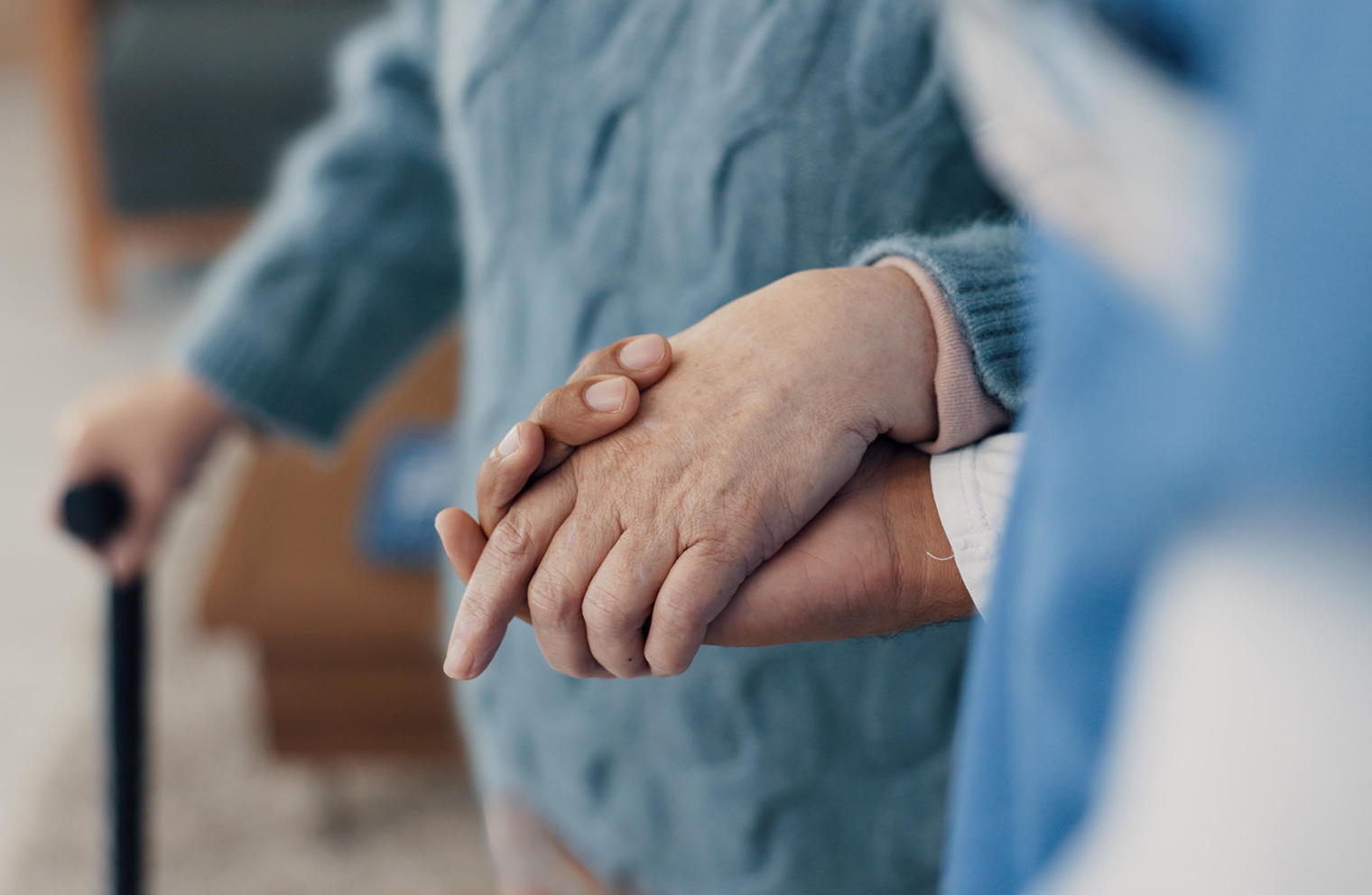 A patient advocate holds the hand of someone dealing with a complex health issue.