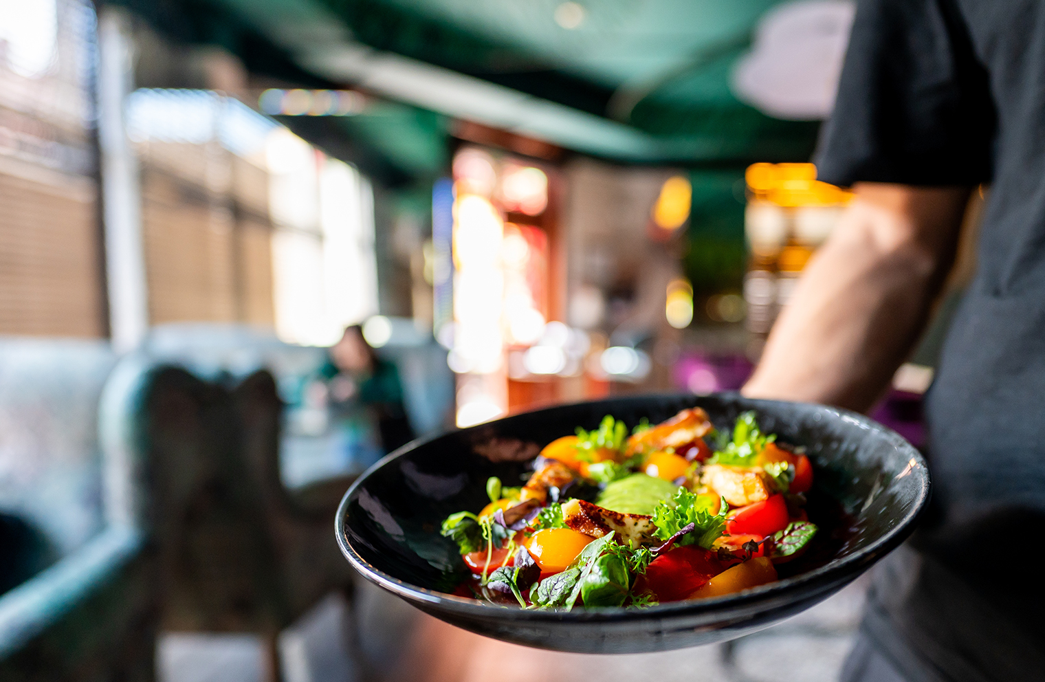 A server brings a healthy dish to the table in a restaurant.