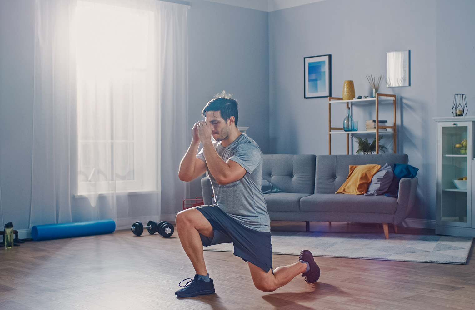 A man exercises in his living room to incorporate physical activity into his day. 