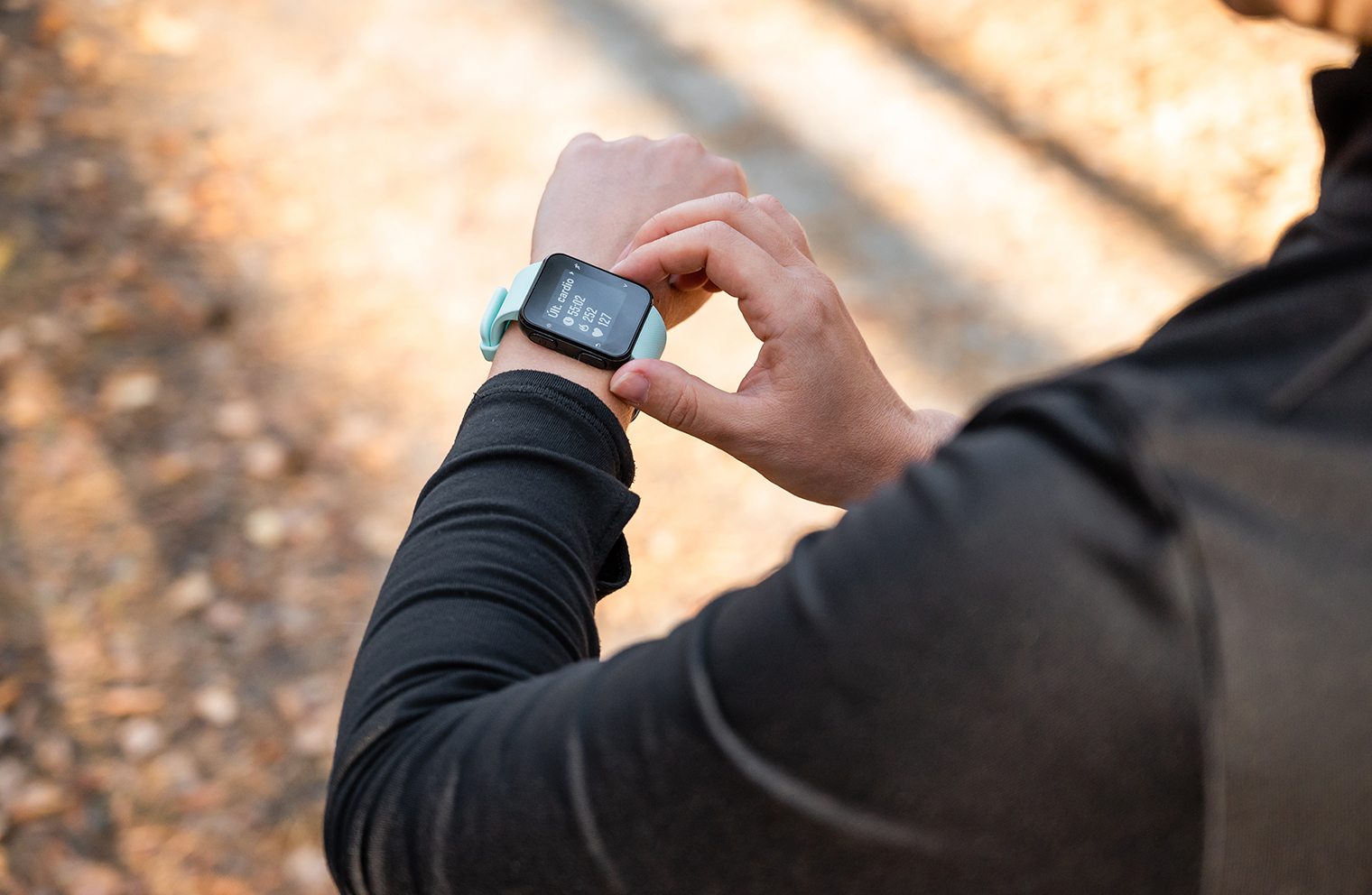 A man uses a wearable device to track his fitness goals as he walks outdoors.