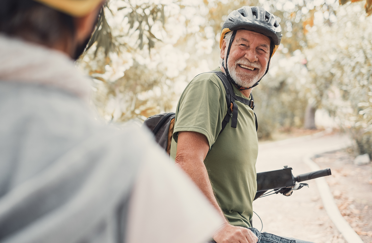 A man bikes with a friend to reach his fitness goals.