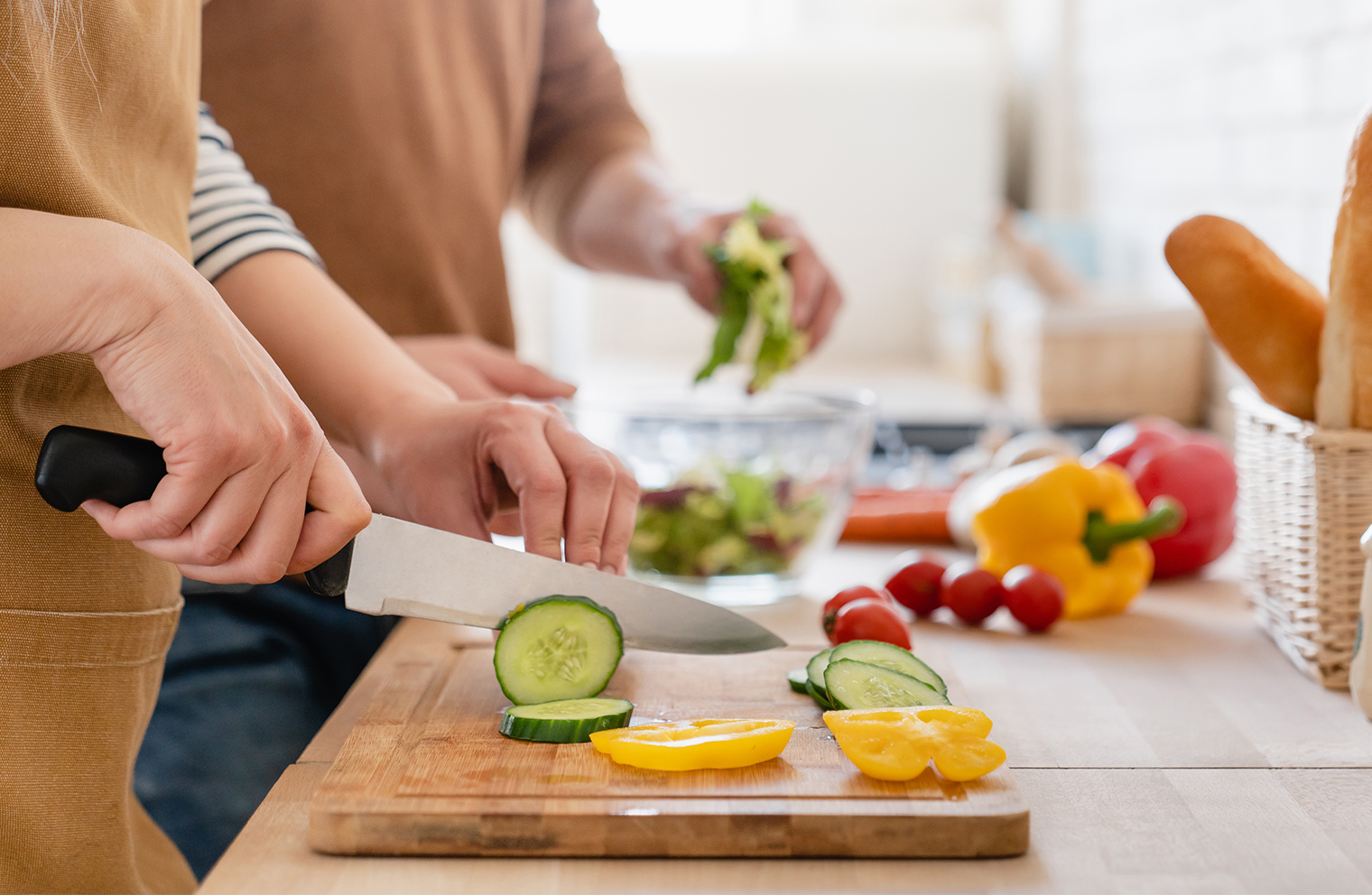 A man and woman slide vegetables for healthy meal prepping.