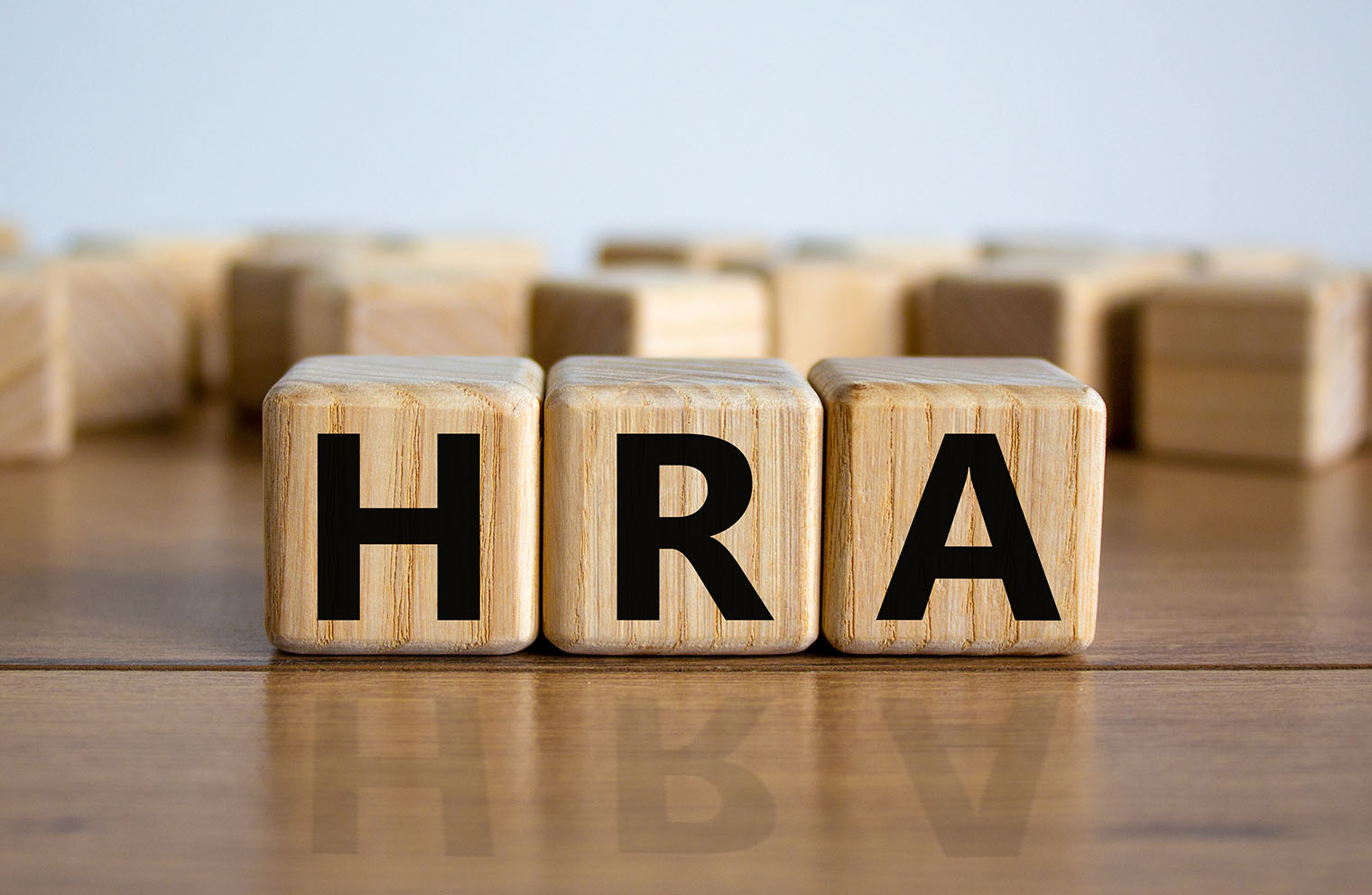 Three wooden blocks with letters that spell “HRA”.