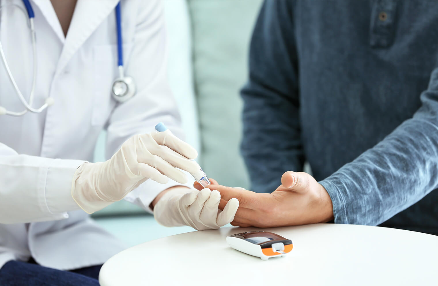 Picture of a doctor pricking a patient's finger for a blood glucose measurement.