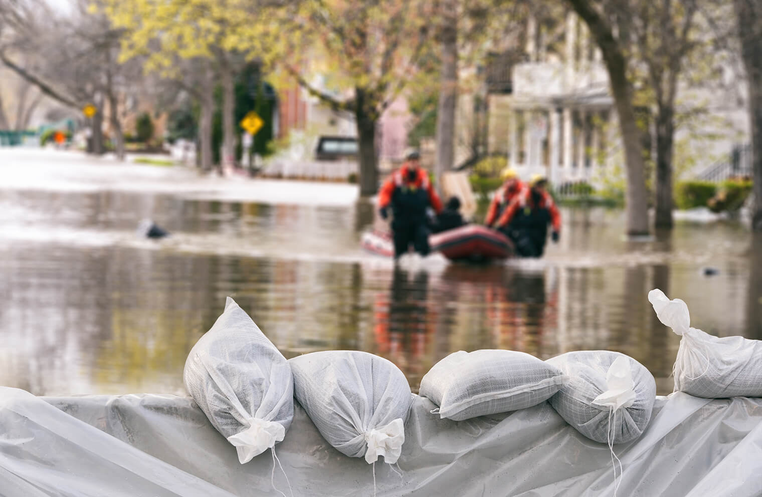 Emergency workers pull a raft through a flooded residential area. 