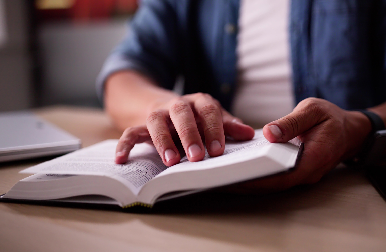 A pair of hands holding a Bible open