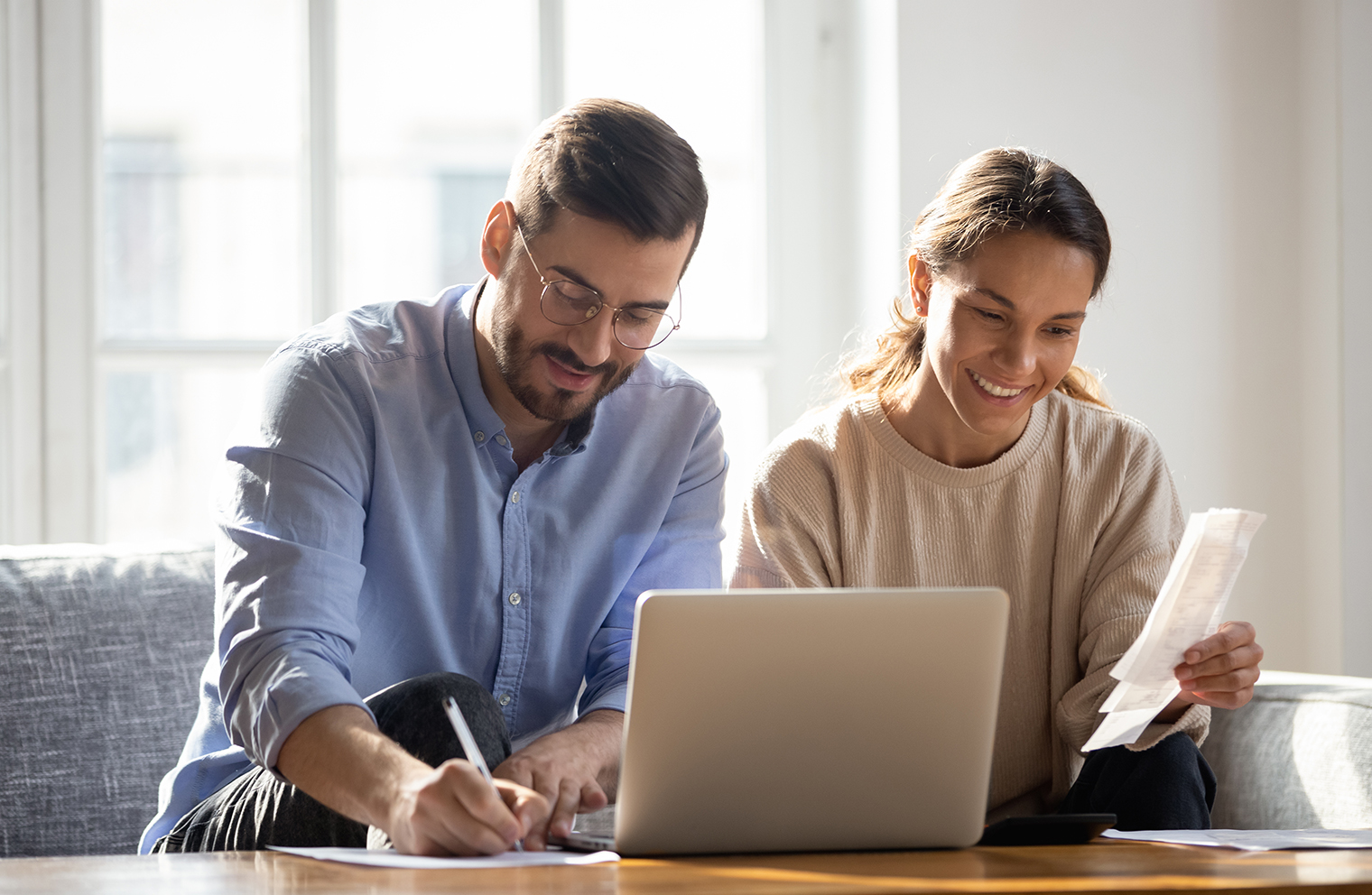 A husband and wife look at a laptop together.