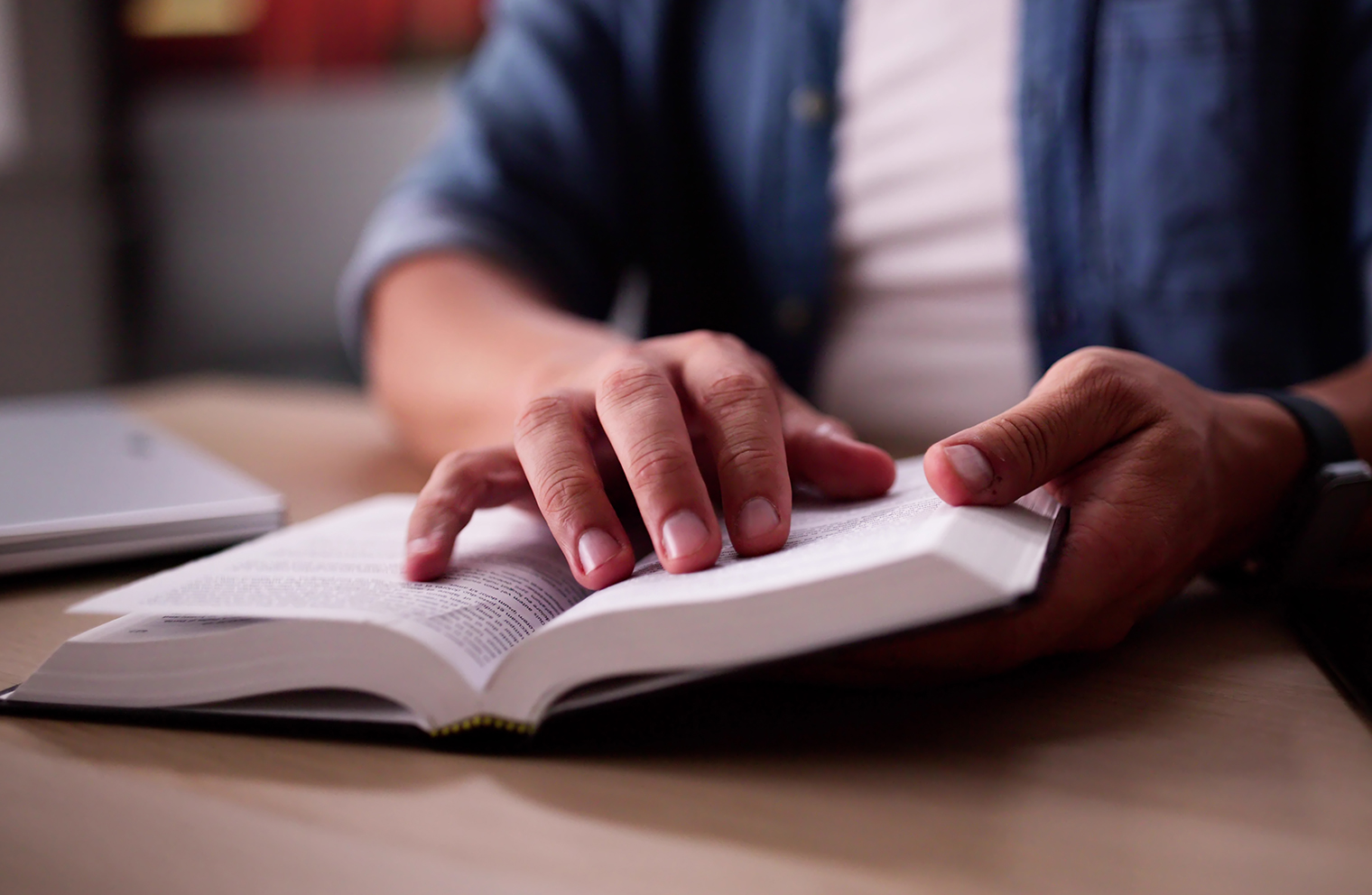 A person’s hands on an open Bible