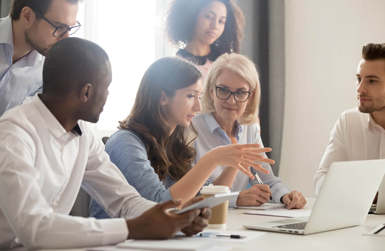 Picture of employees talking around a computer.